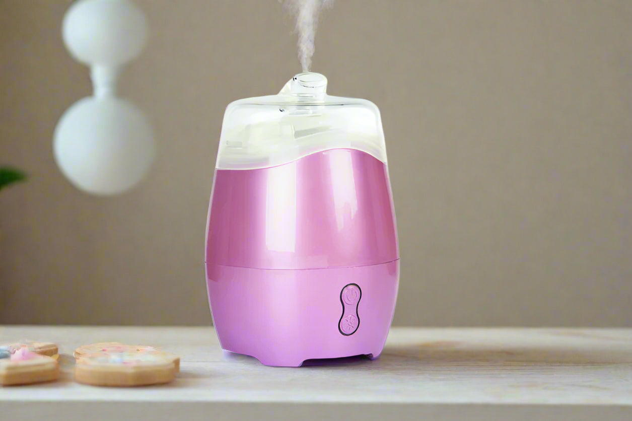 Nutshell Aroma Natural Vaporiser - Pink diffuser releasing steam on wooden surface