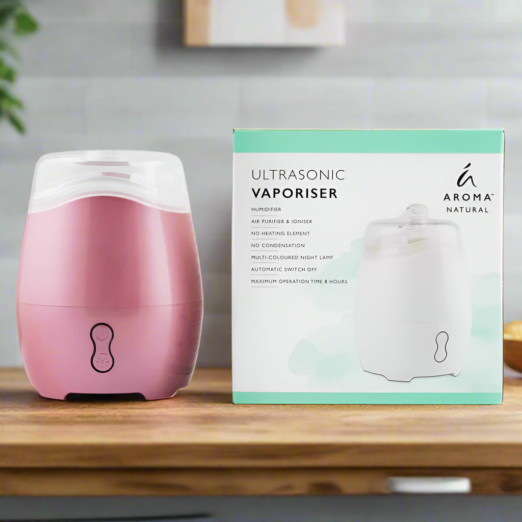 Nutshell Aroma Natural Vaporiser - Pink ultrasonic diffuser with humidifier on wooden table next to its packaging box