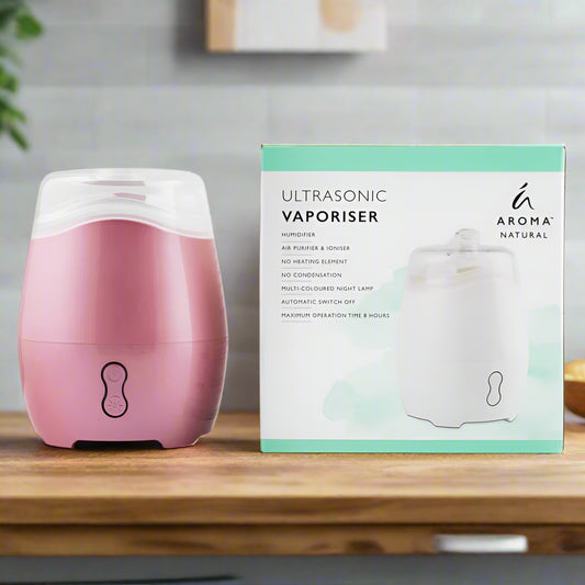 Nutshell Aroma Natural Vaporiser - Pink ultrasonic diffuser with humidifier on wooden table next to its packaging box