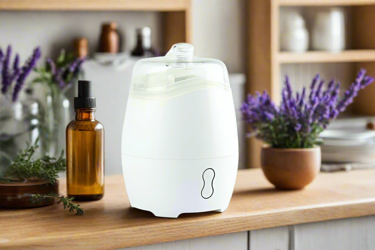 Nutshell Aroma Natural Vaporiser White diffuser on wooden countertop with essential oil bottle and lavender