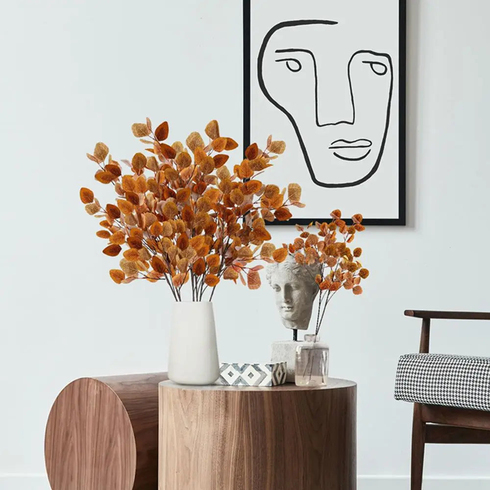Artificial eucalyptus bouquet in an elegant vase on a modern coffee table with abstract art