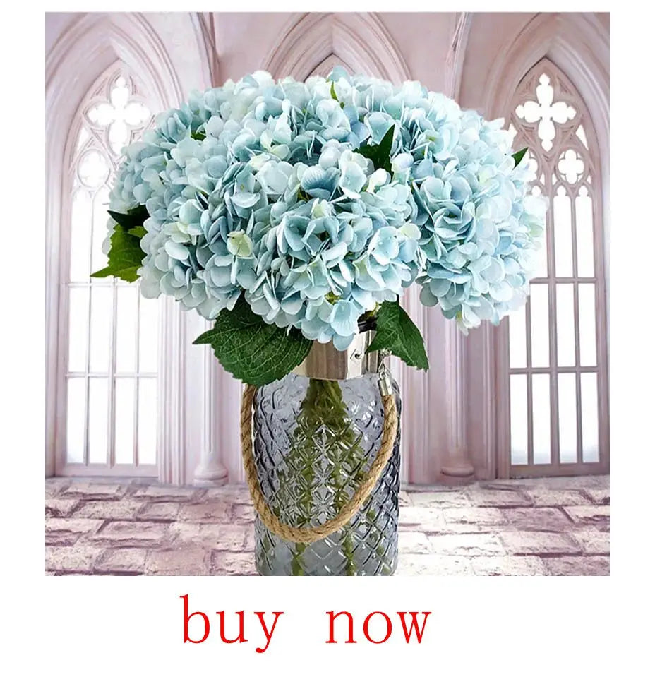 Artificial eucalyptus bouquet in light blue arranged in a decorative glass vase with rope detailing