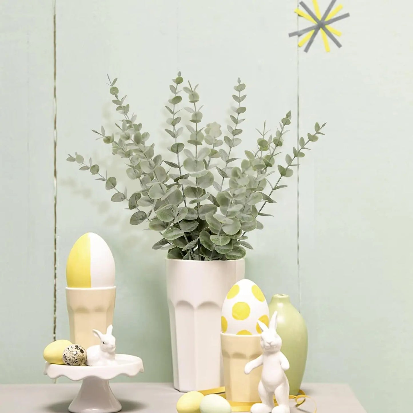 Artificial eucalyptus wall hanging decor in a white vase with pastel Easter decorations