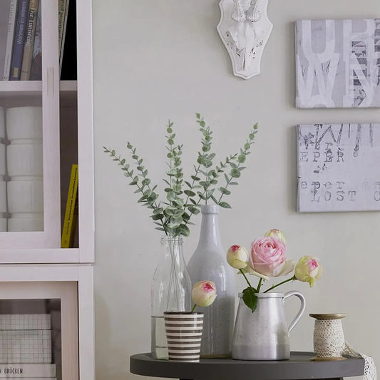 Artificial eucalyptus wall hanging decor with stylish glass vases and fresh floral arrangements