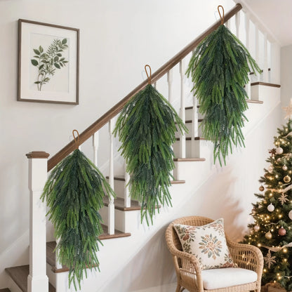 Artificial pine teardrop wreath hanging elegantly on a staircase railing for festive decor