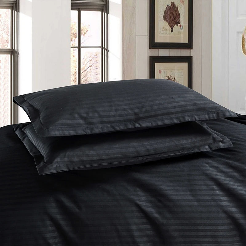Nutshell black satin duvet cover set with striped texture on bed with matching pillowcases