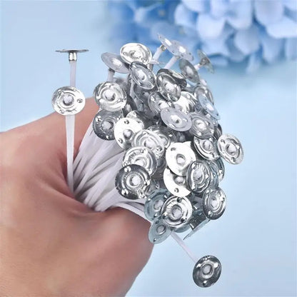 Hand holding a bundle of Nutshell pre-waxed candle wicks with metal tabs for candle making