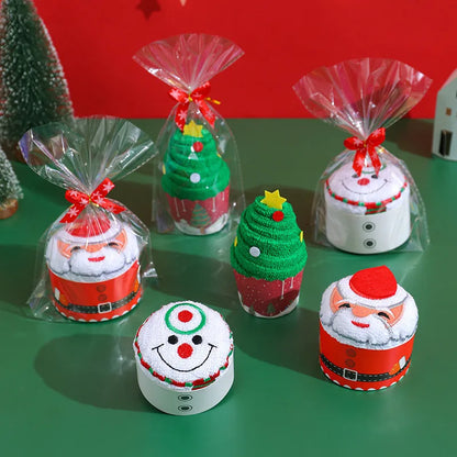 Christmas cake shaped hand towels in festive designs, including Santa and a Christmas tree, packaged for gifting