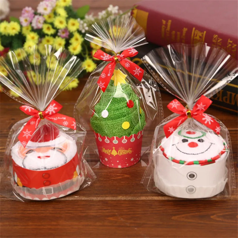 Festive Christmas cake shaped hand towels in decorative packaging with Santa, snowman, and Christmas tree designs