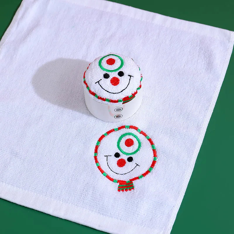 Christmas cake shaped hand towels featuring smiling snowman designs in festive colors