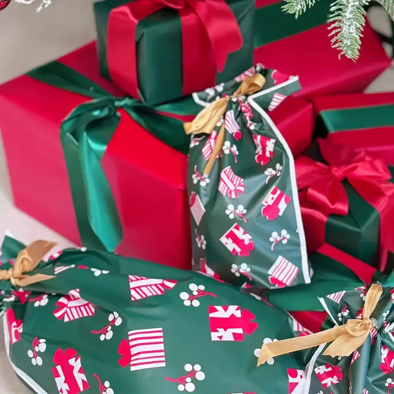 Christmas Drawstring Gift Bags with Ribbon in festive green and red designs among wrapped presents