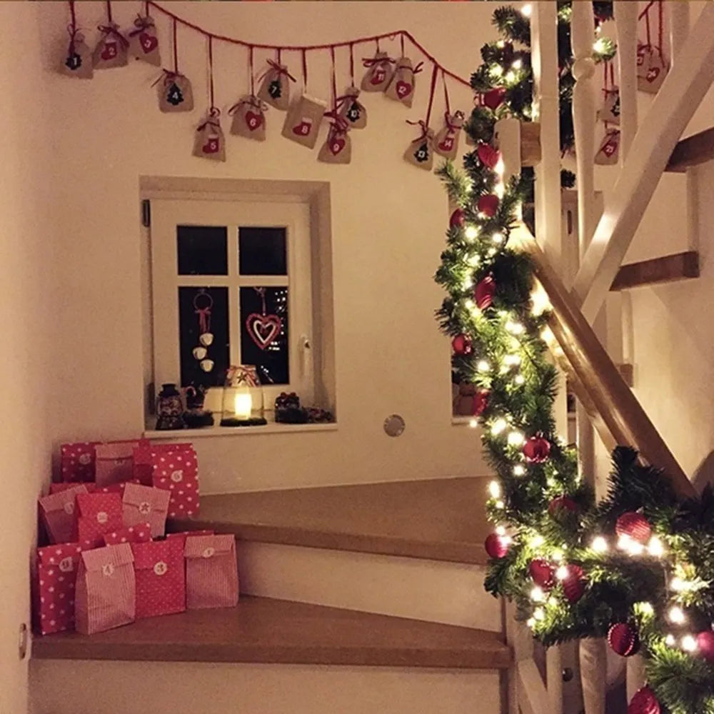 Decorative Christmas garland with lights adorning a staircase and surrounding holiday gifts
