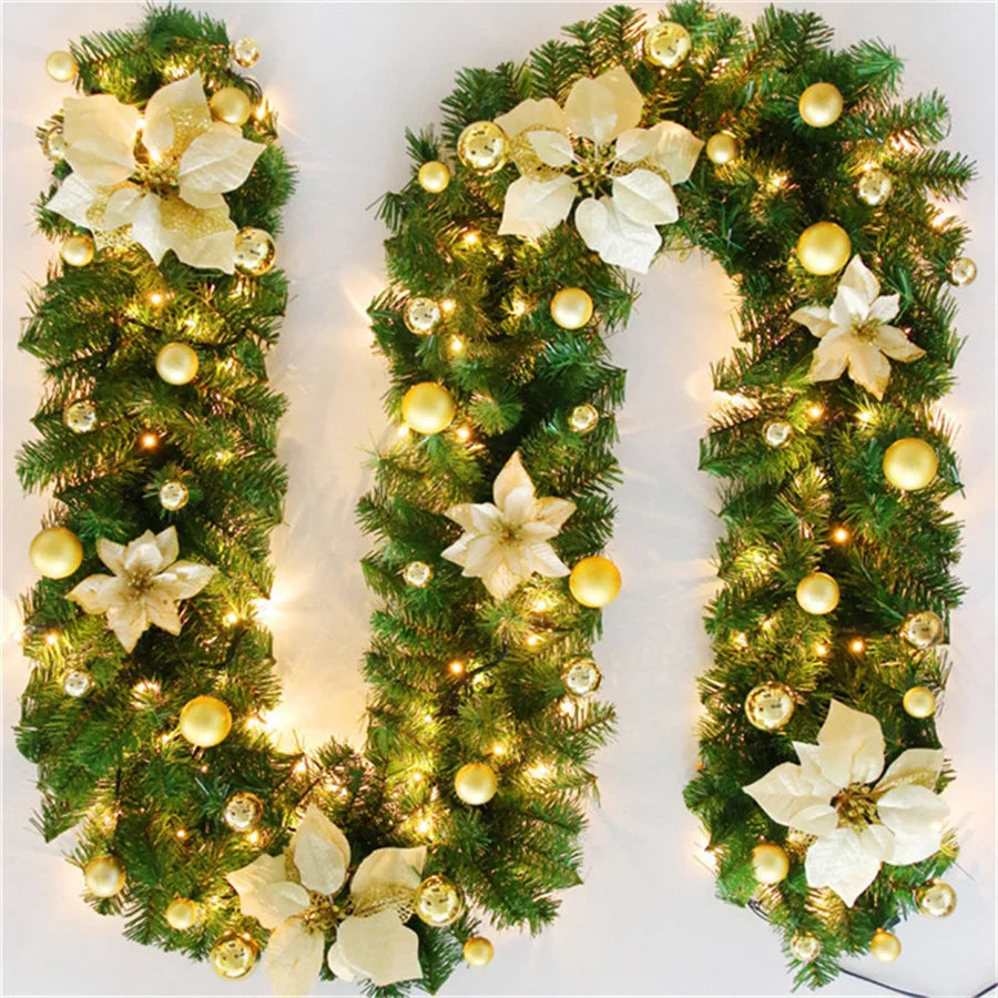 Nutshell Christmas garland with lights featuring gold ornaments and white poinsettias for festive decor