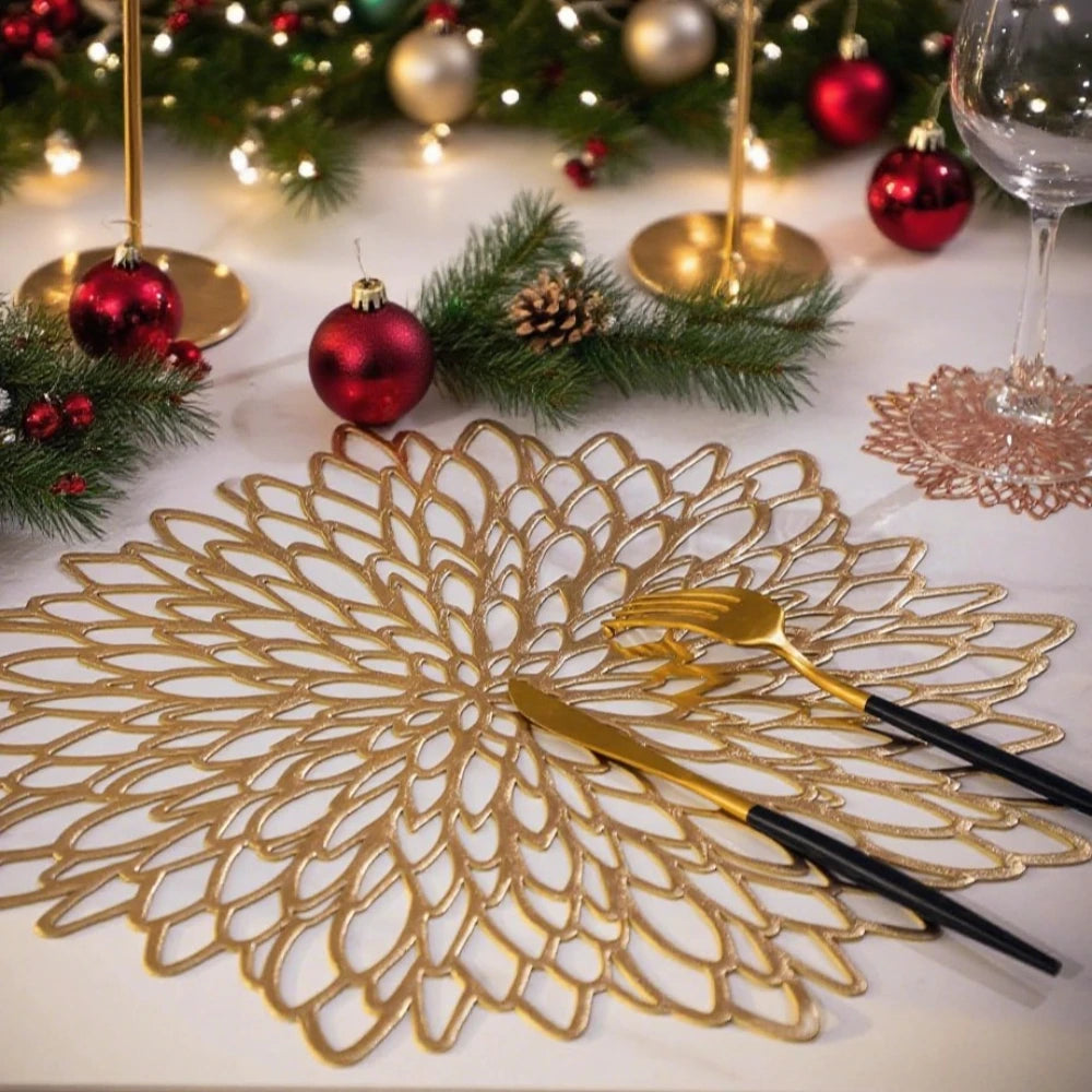 Elegant gold table setting with Christmas placemats, decorative ornaments, and stylish cutlery