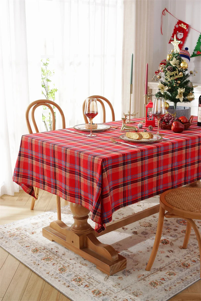 Christmas Plaid Tablecloth in red and green on a wooden dining table set for a festive holiday meal