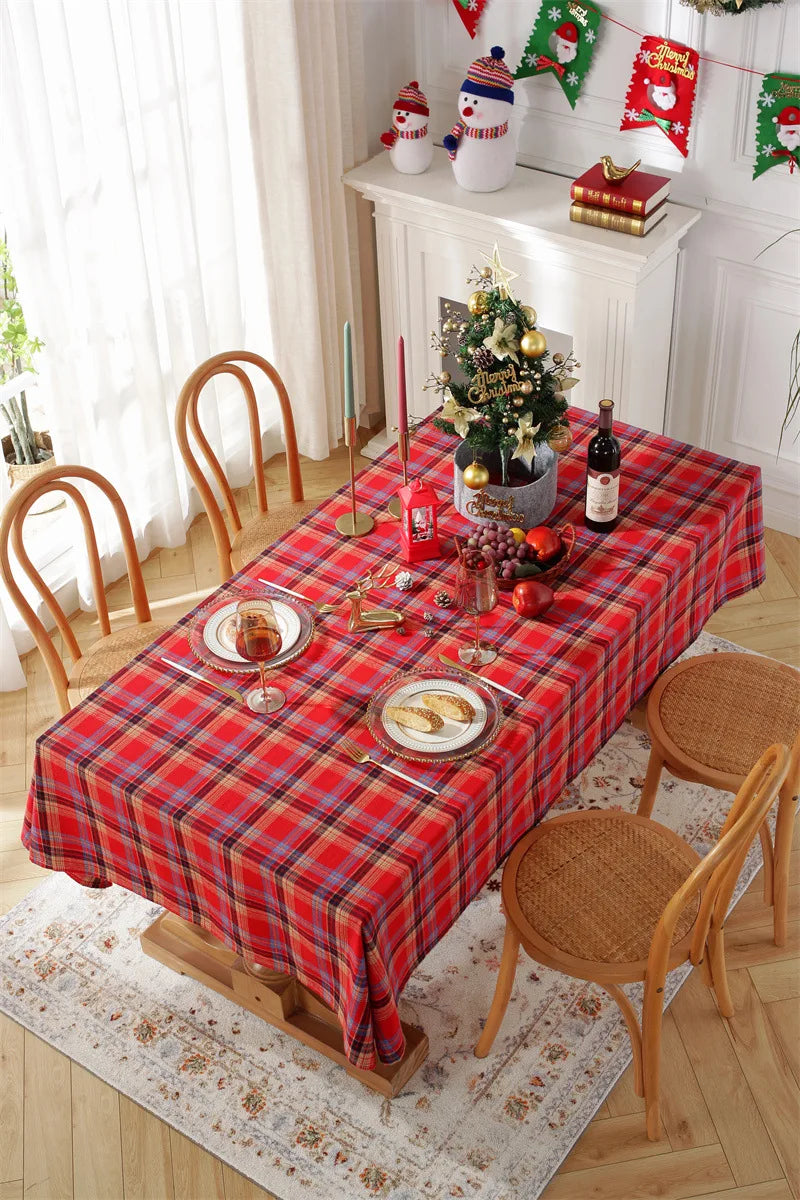 Christmas Plaid Tablecloth on a dining table decorated for the holiday season with plates and candles