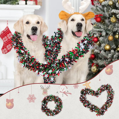 Two golden retrievers with Christmas snowflake tinsel garland around their necks, festive decor in the background.