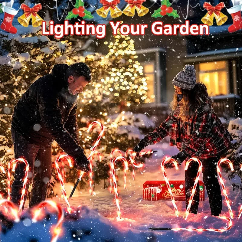Couple installing Christmas solar candy cane lights in a snowy garden with festive decorations