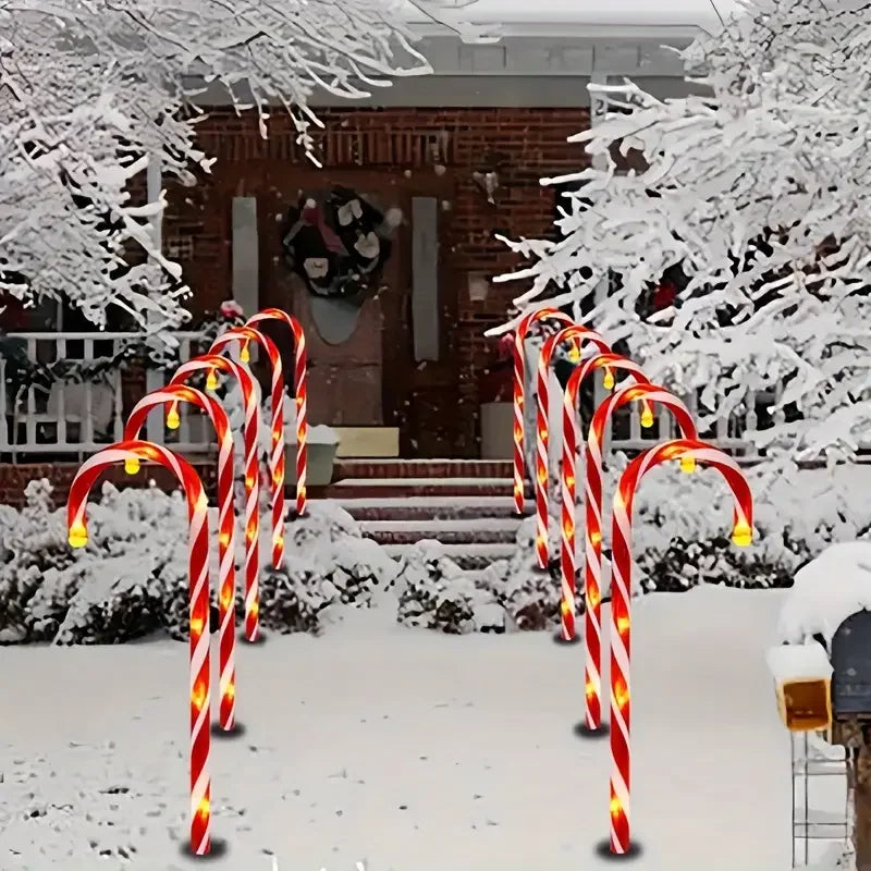 Christmas solar candy cane lights illuminating a snowy yard pathway for festive outdoor decoration