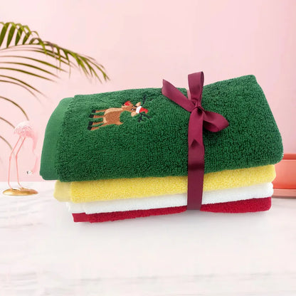 Set of Christmas themed hand towels in green, red, and yellow with festive reindeer design