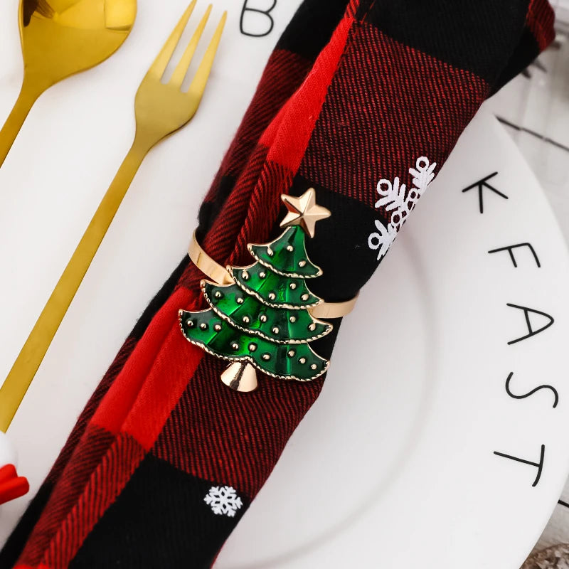 Festive Christmas tree napkin rings with a gold finish and green embellishments on a plaid napkin
