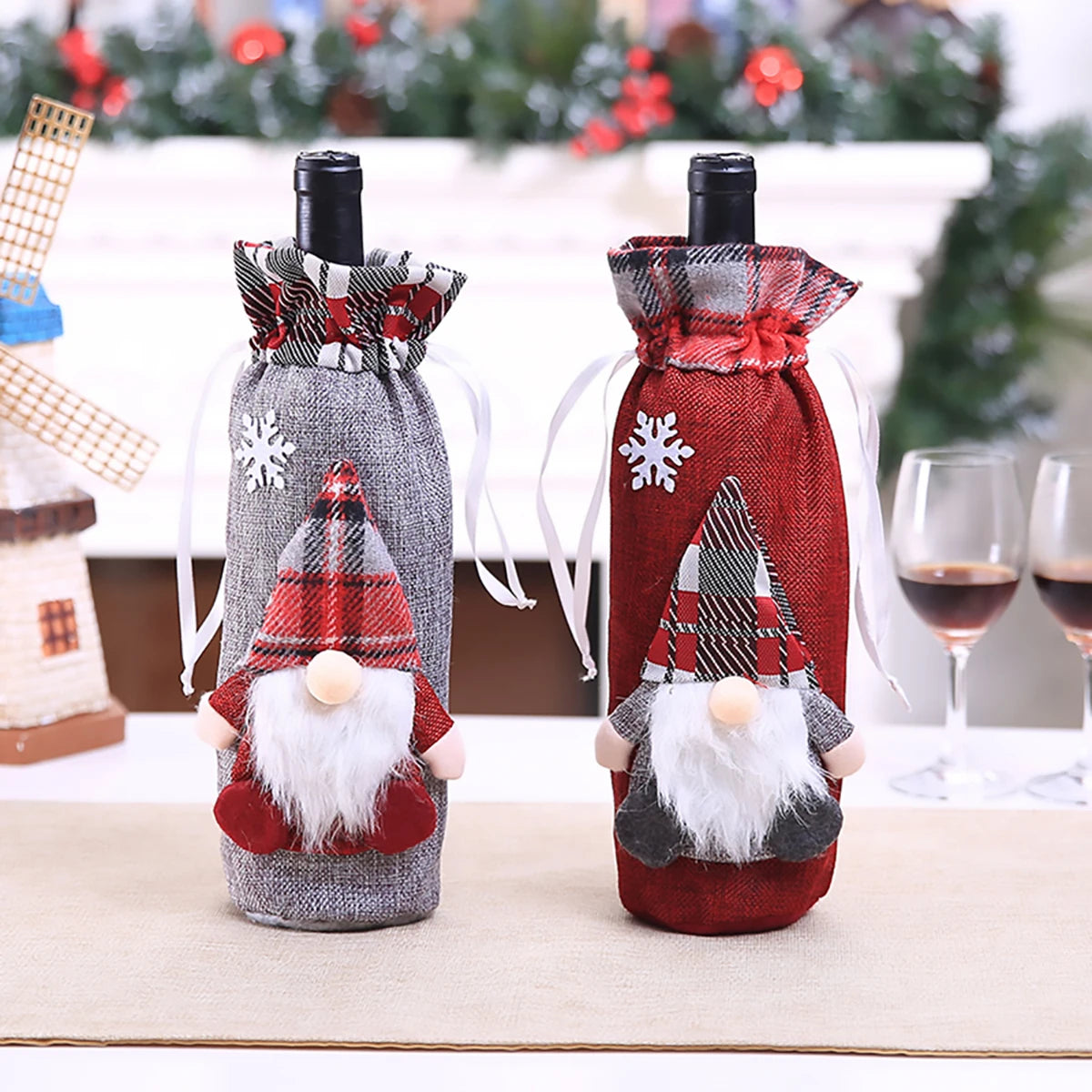 Two festive Christmas wine bottle covers in gray and red with gnome designs for holiday gifting