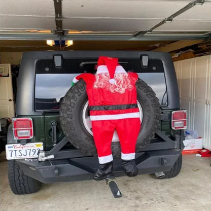 Climbing Santa Claus decoration on a Jeep spare tire for festive holiday cheer