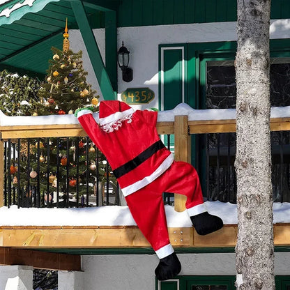 Nutshell Climbing Santa Claus Decoration Hanging from a Balcony with Snow on the Ground
