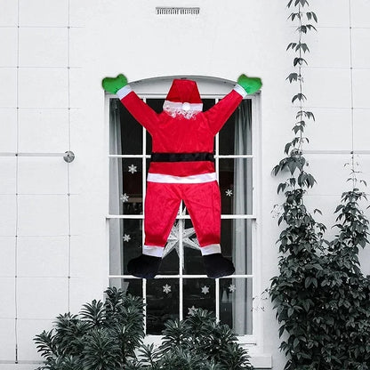Climbing Santa Claus decoration hanging from a window with festive snowflakes in the background