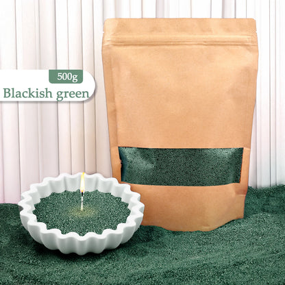 Nutshell blackish green colored candle sand 500g bag with a lit candle in green sand