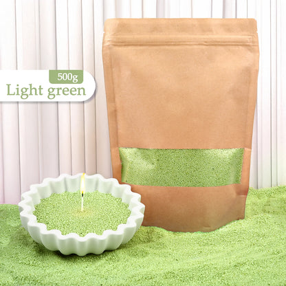 Nutshell light green colored candle sand 500g pack with candle in white ceramic dish