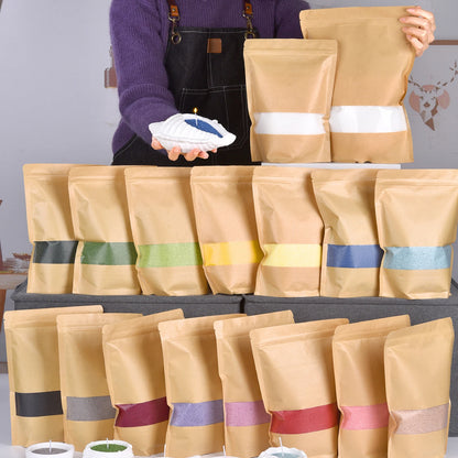 Nutshell colored candle sand in various shades packaged in brown resealable bags displayed with a person holding blue sand