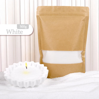Nutshell white colored candle sand 500g pack with a lit white candle in a scalloped holder