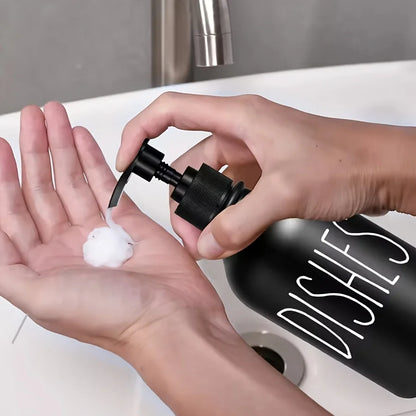Nutshell black countertop soap dispenser set with foam soap being dispensed into hand over white sink
