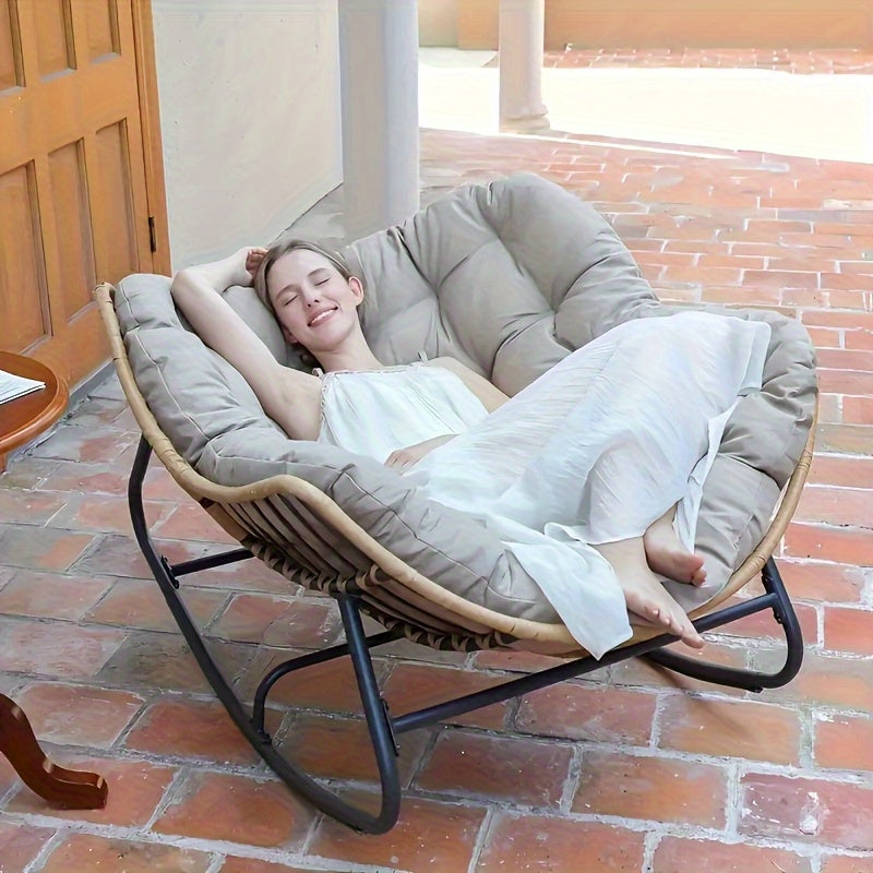 Nutshell comfortable patio chair cushion on round rattan papasan chair with woman reclining on tiled patio