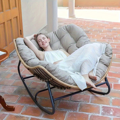 Nutshell comfortable patio chair cushion on round rattan papasan chair with woman reclining on tiled patio