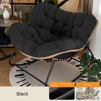Nutshell black rattan frame lazy leisure rocking chair with cushion on metal rocking base in living room