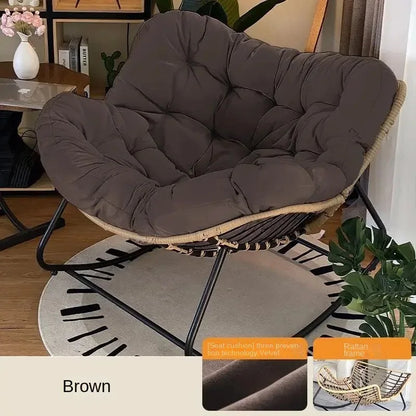 Nutshell brown lazy leisure rocking chair with cushion on rattan frame and black metal rocker base in living room
