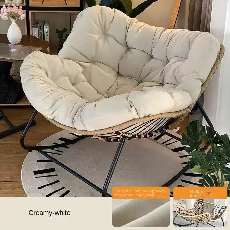 Nutshell creamy white lazy leisure rocking chair with cushion rattan frame on black metal rocker base in living room