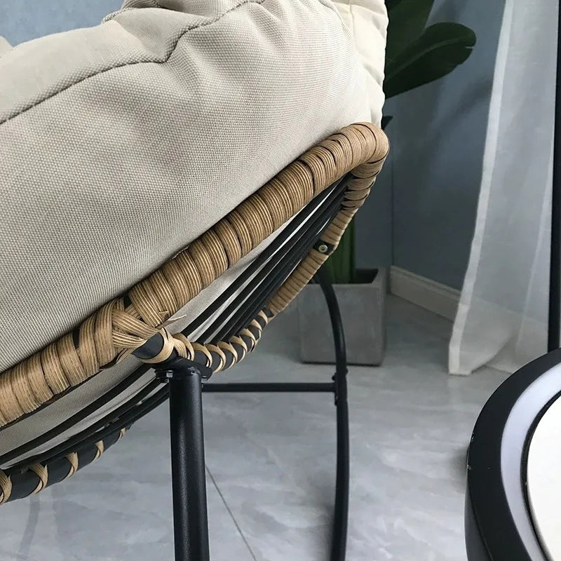 Nutshell lazy leisure rocking chair with cushion featuring rattan wrapped edge black metal frame cream cushion