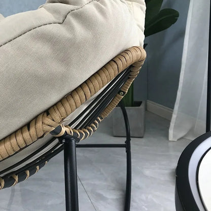 Nutshell lazy leisure rocking chair with cushion featuring rattan wrapped edge black metal frame cream cushion