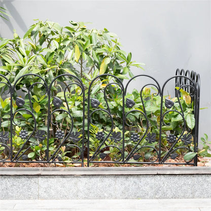 Nutshell decorative garden fence panels with black metal floral design surrounding green plants