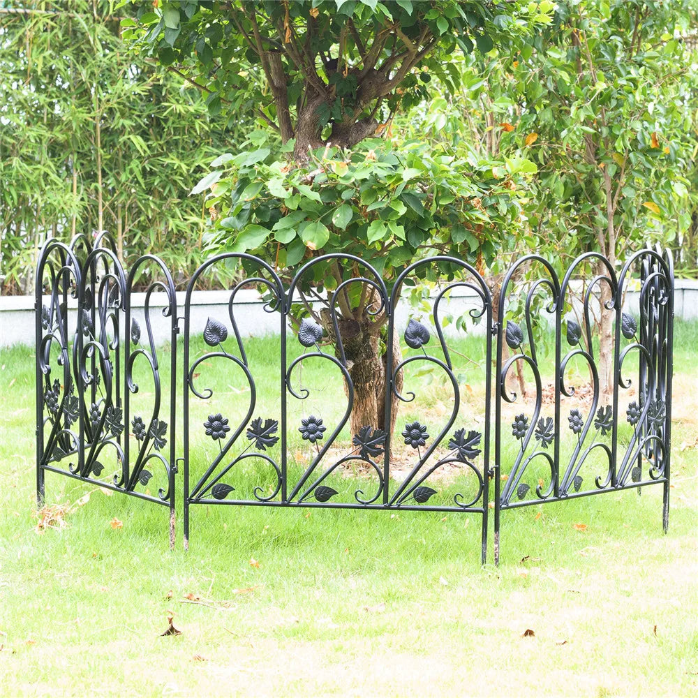 Nutshell black decorative garden fence panels with floral and leaf designs surrounding a tree