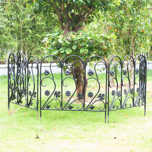 Nutshell black decorative garden fence panels with floral and leaf designs surrounding a tree