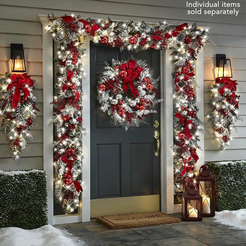 Front door Christmas garland decorations with red bows and lights for festive holiday decor
