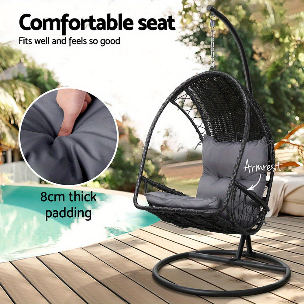 Nutshell outdoor egg chair hammock with thick padded seat and armrest on black stand by pool