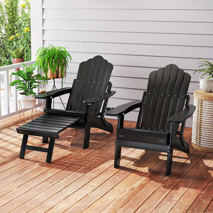 Black adjustable Adirondack chair with footrest on wooden deck surrounded by plants