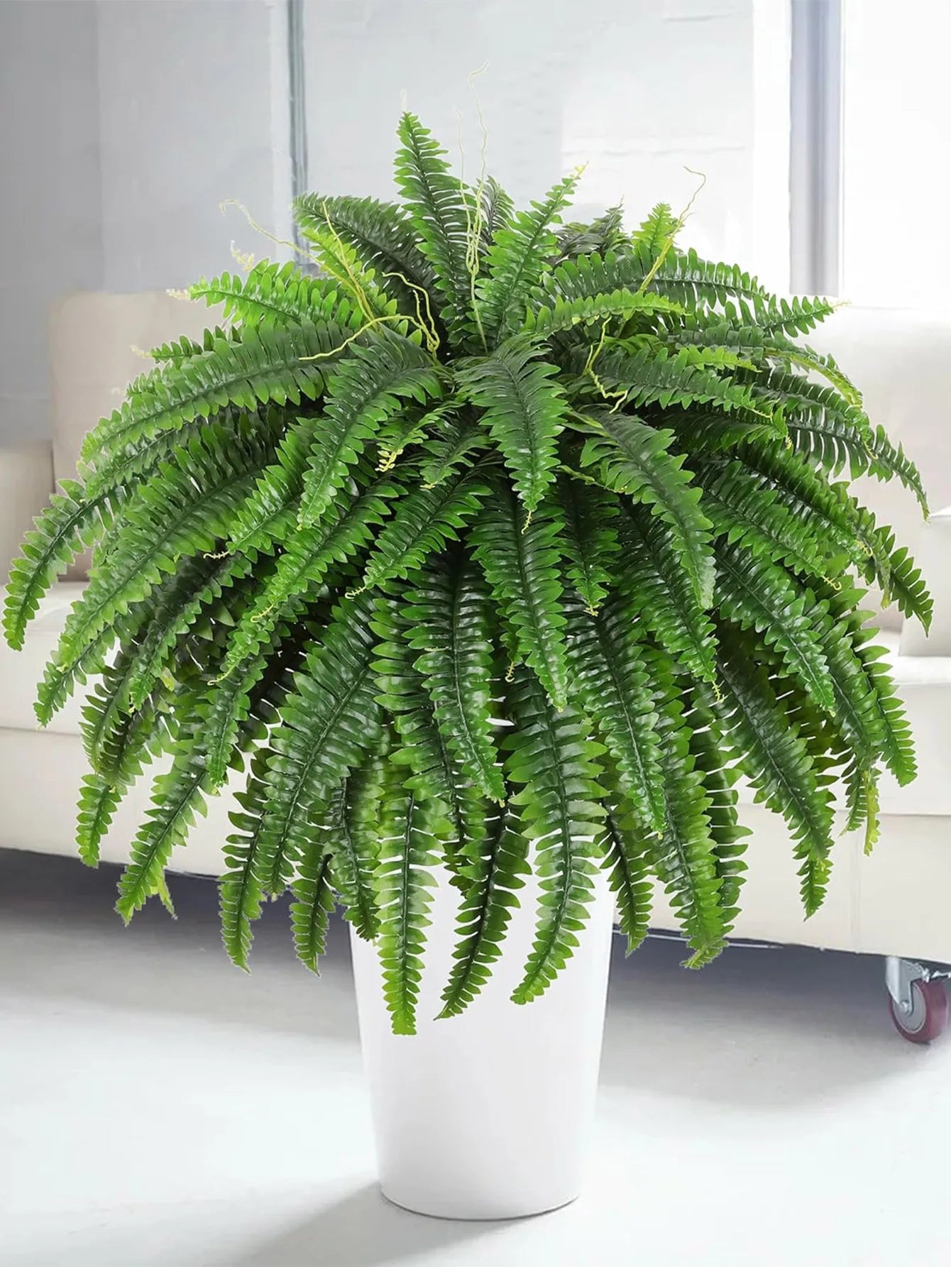 Nutshell artificial fern hanging plant in white planter used as lush living room accent