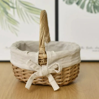 Nutshell handcrafted wicker basket with beige fabric lining and bow sitting on wooden surface
