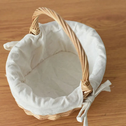 Nutshell handcrafted wicker basket with white fabric lining and sturdy handle on wooden surface